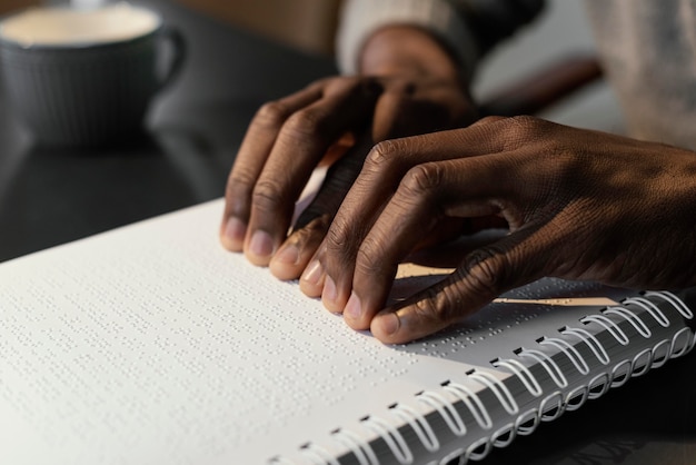 Hands reading braille notebook