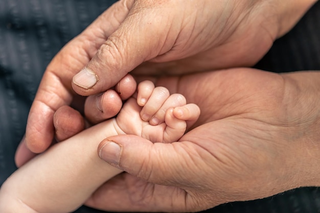 고위 사람과 작은 아기의 손을 닫습니다