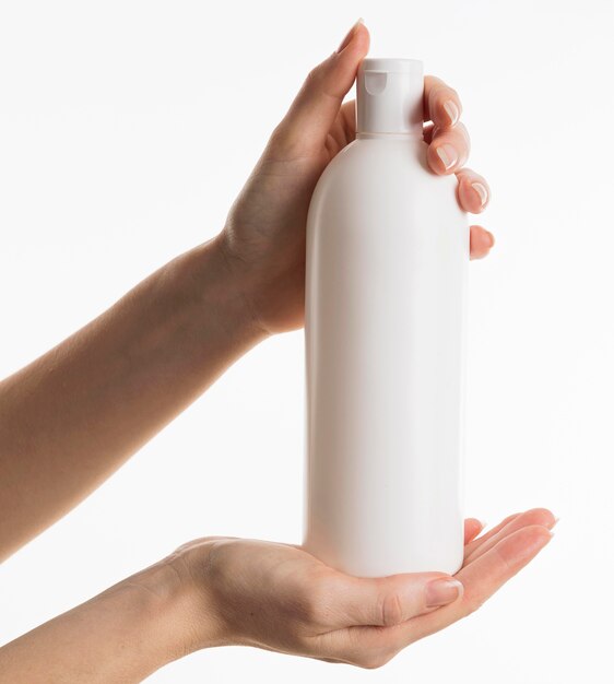 Hands showing cosmetic bottle