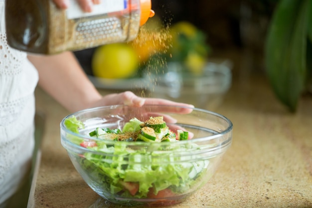 Mani che sprizzano un'insalata verde