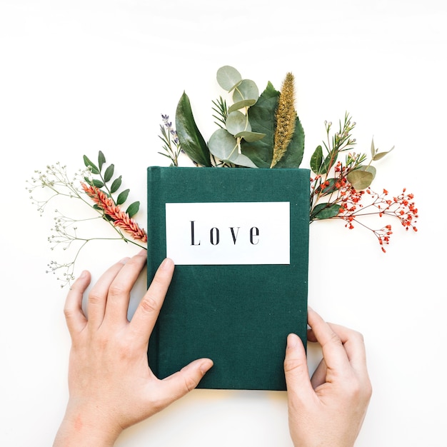 Hands touching book and leaves