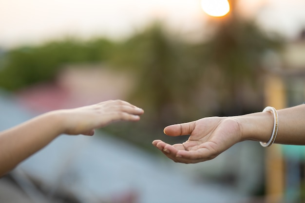 Hands of two people reaching out to one another