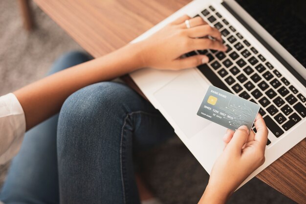 Hands typing and holding a credit card