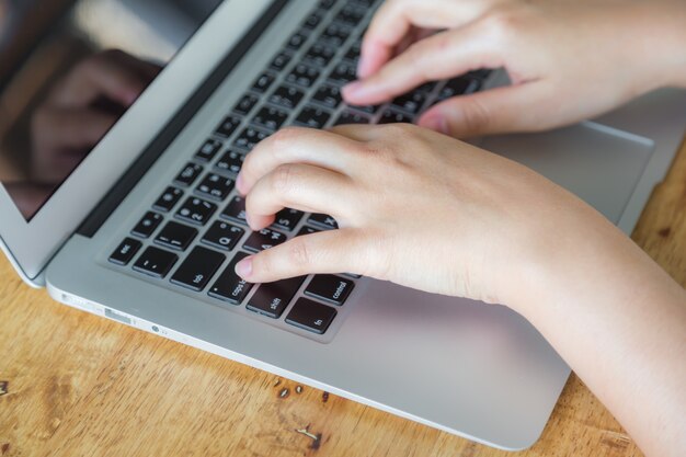 Hands typing on a laptop