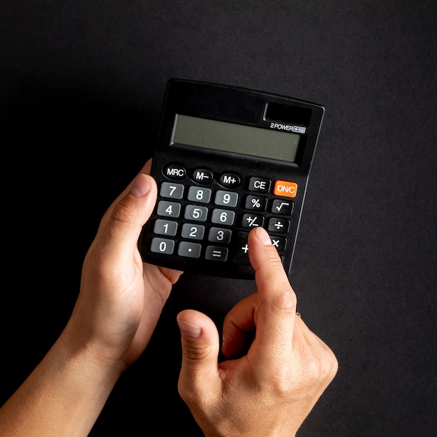 Hands using  black mini calculator