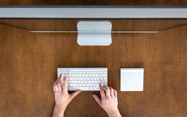 Foto gratuita mani che usano un computer mentre sono seduti al tavolo