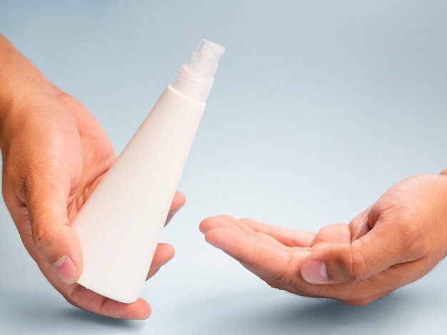 Hands using lotion bottle mock-up