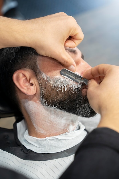 Foto gratuita mani che usano la lama da barba da vicino