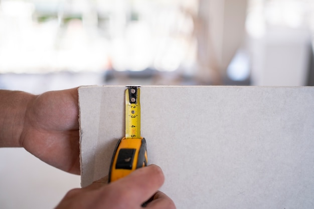 Hands using tape measuring tool for placard