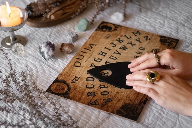 Hands using wooden ouija board