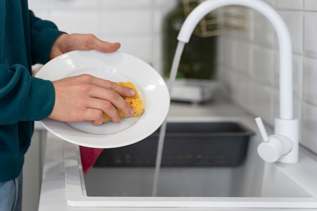Hands washing dish with sponge