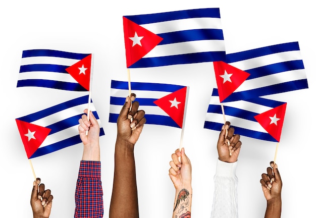 Free photo hands waving flags of cuba