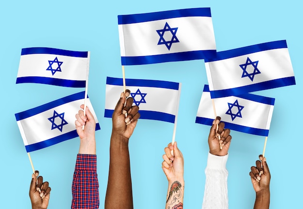 Hands waving flags of Israel