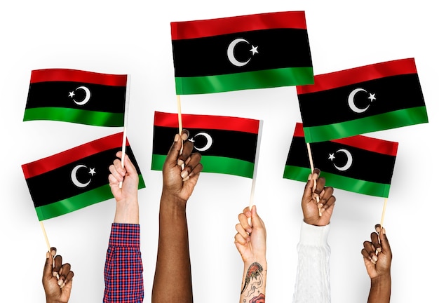 Foto gratuita mani sventolando bandiere della libia