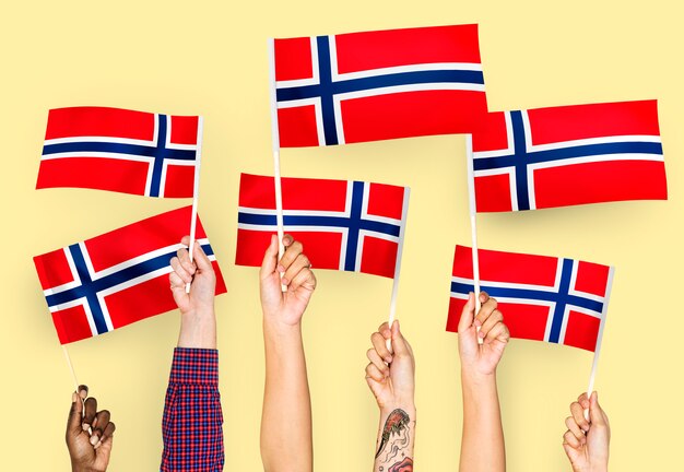 Hands waving flags of Norway