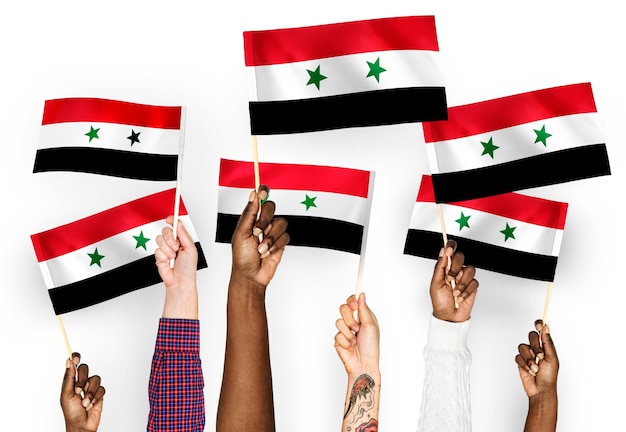 Hands waving flags of Syria