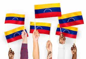 Free photo hands waving flags of venezuela