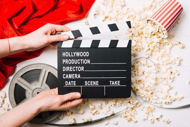 Hands with clapperboard at popcorn