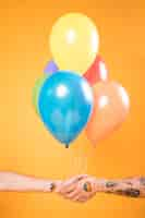 Free photo hands with colorful balloons