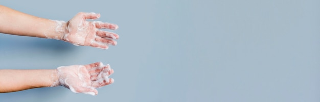 Hands with foam from soap and copy space