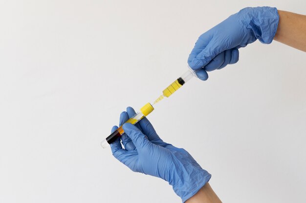 Hands with gloves holding injection