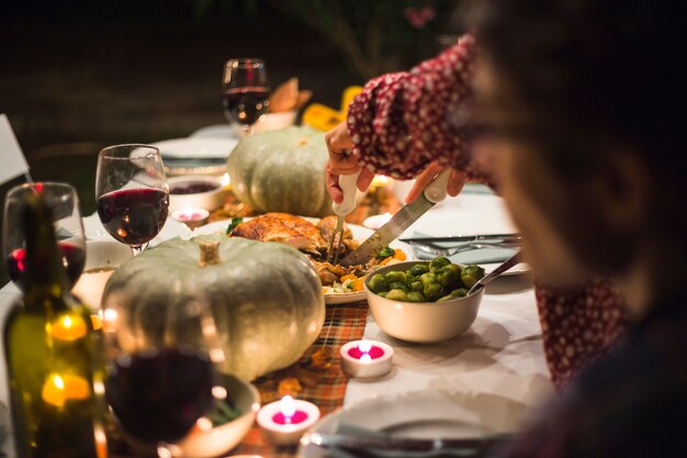 Hands with knife cutting roasted meat