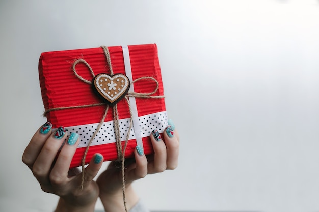 Hands with painted nails holding a gift