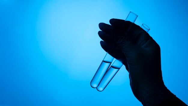 Hands with protective gloves holding medical tube