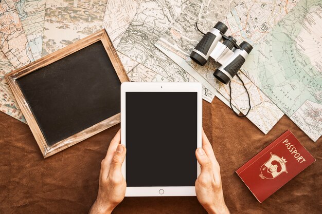 Hands with tablet at desk with maps