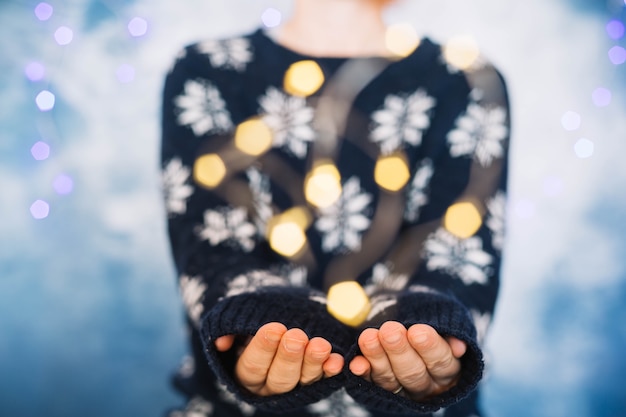 Foto gratuita mani di donna e luci sfocate