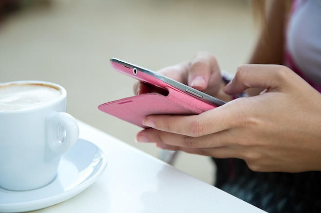 Le mani della donna il telefono cellulare la navigazione