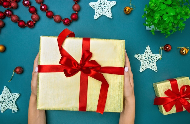 The hands of woman and Christmas gift box.