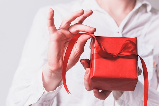 Hands of woman holding a red gift