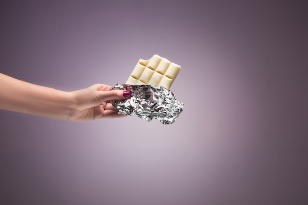 Free photo hands of a woman holding a tile of chocolate