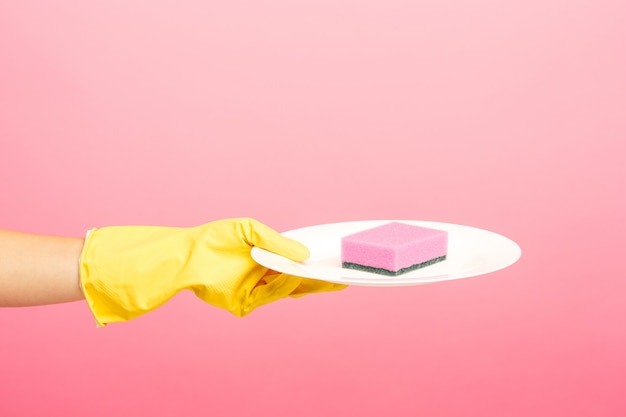 Free photo hands in yellow protective gloves washing a plate