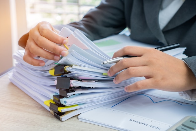 Hands young female business managers checking arranging stack of unfinished documents