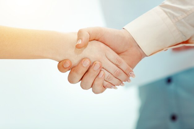 Handshake. Boss approving and congratulating young successful employee of the company for her success and good work.