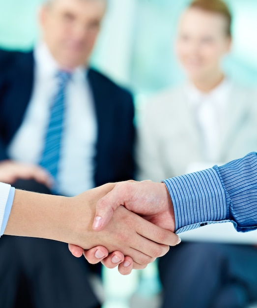 Handshake with businesspeople blurred background