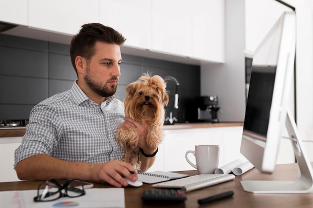 Free photo handsome adult male holding pet while working