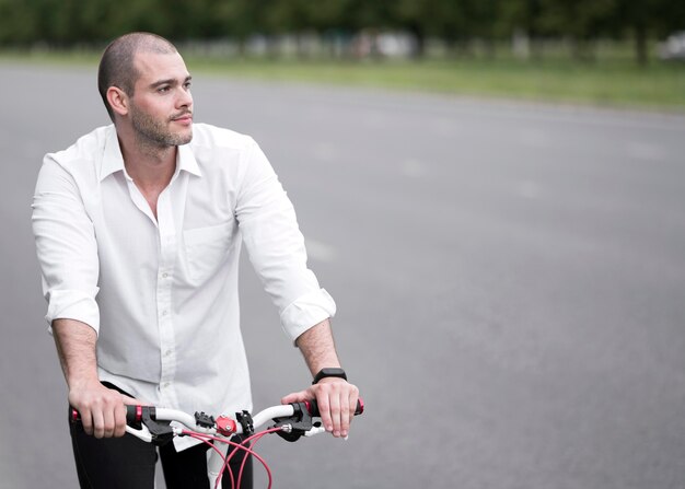 Handsome adult male riding bicycle outdoors