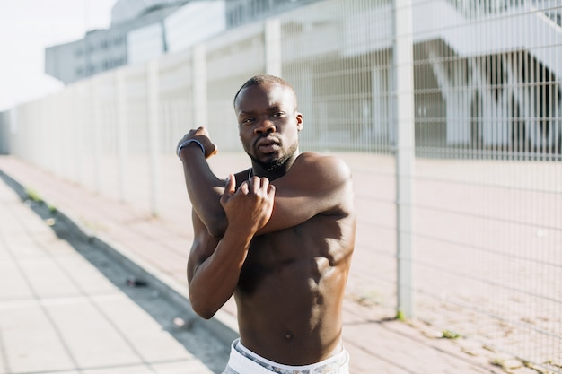 Handsome African American man does stretching before a work-out outside