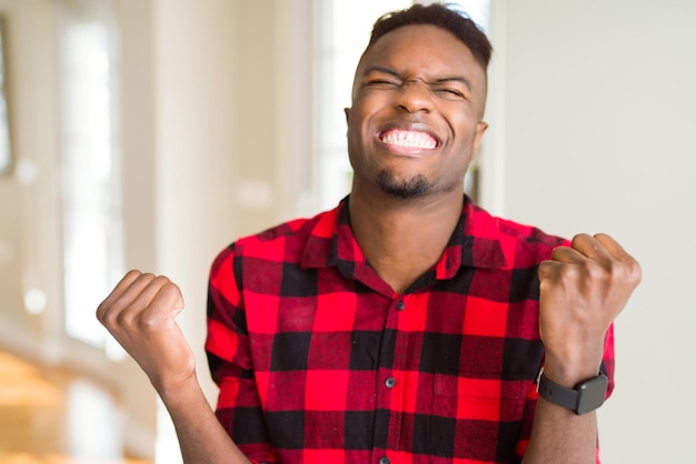 Free photo handsome african american man very happy and excited doing winner gesture with arms raised smiling and screaming for success celebration concept