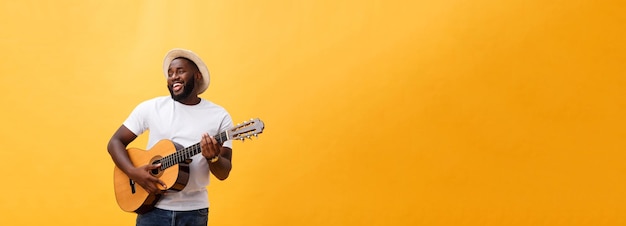 노란색 backgrou에 고립 된 어쿠스틱 기타를 연주 잘 생긴 아프리카계 미국인 복고풍 스타일 기타리스트