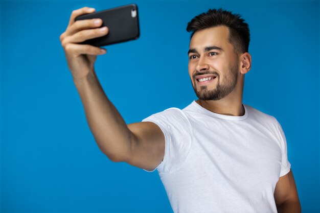 ハンサムなアメリカ人は、selfieとカメラに笑顔を取る