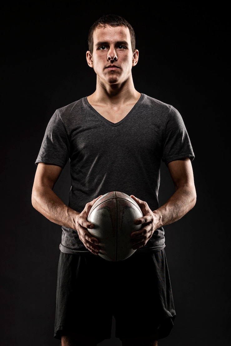 Free Photo handsome athletic male rugby player holding ball