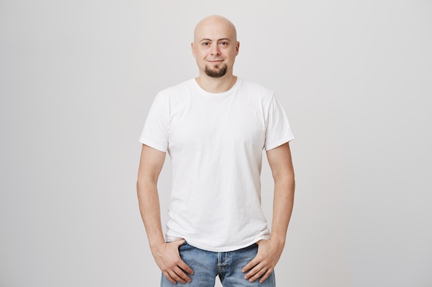 Handsome bald middle-aged man with beard wearing casual white t-shirt