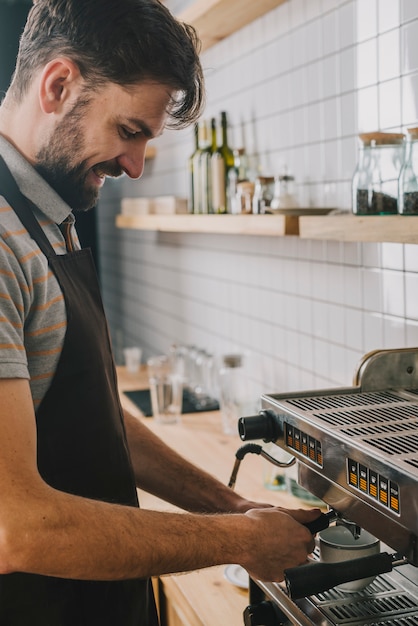 Free photo handsome bartender making coffee