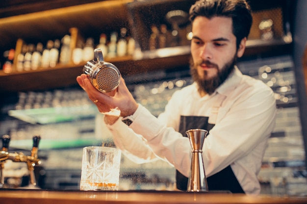 Бесплатное фото Красивый бармен делает пить и коктейли на прилавке