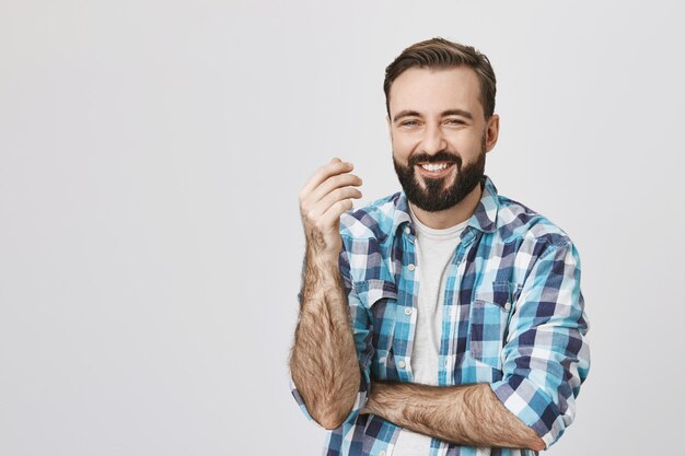 Handsome bearded adult man laughing over joke