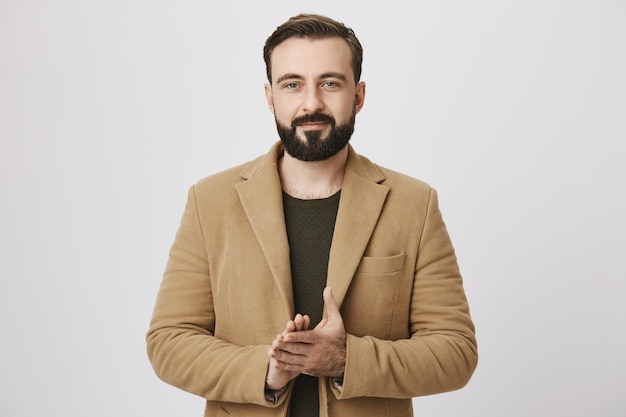 Free photo handsome bearded businessman rubbing hands, having deal